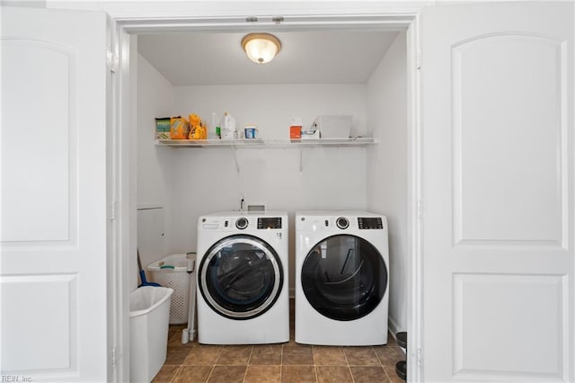 laundry room featuring washing machine and dryer and dark tile patterned flooring