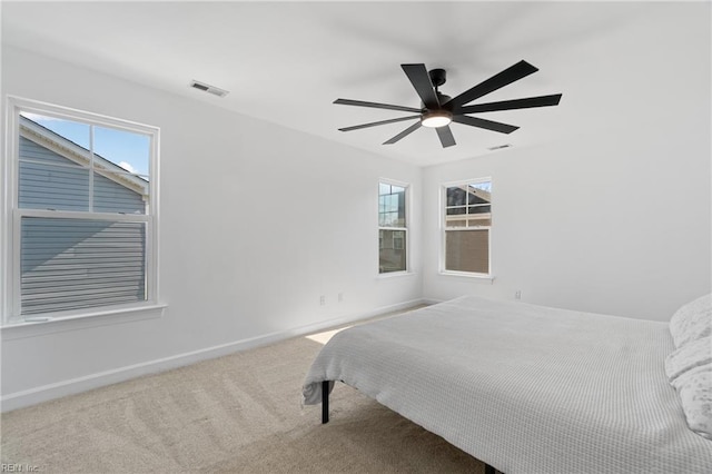 carpeted bedroom featuring multiple windows and ceiling fan