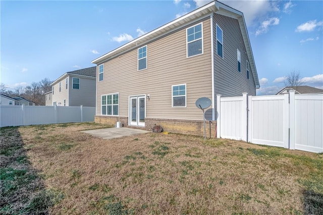 rear view of property featuring a lawn and a patio area