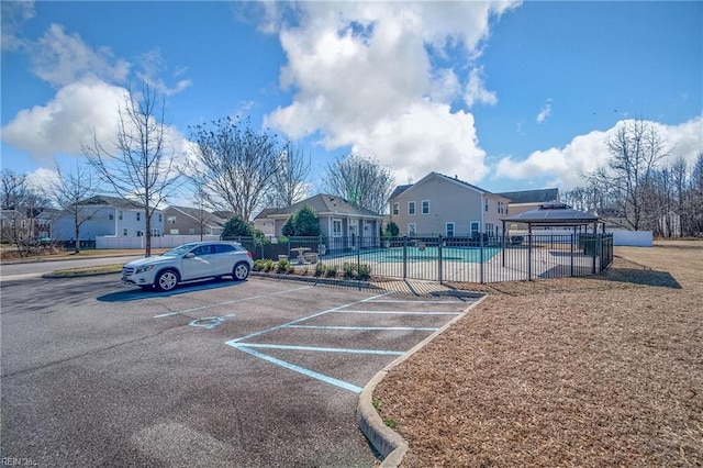 view of parking / parking lot featuring a gazebo and a community pool