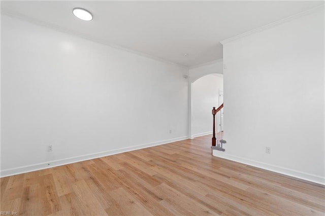 empty room with crown molding and light hardwood / wood-style flooring