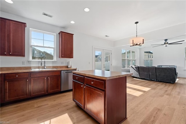 kitchen with a kitchen island, dishwasher, sink, hanging light fixtures, and french doors