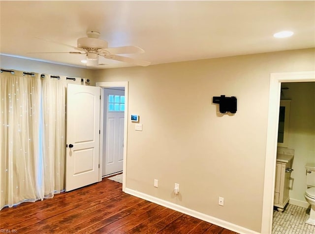 unfurnished bedroom featuring wood-type flooring, ensuite bathroom, and ceiling fan