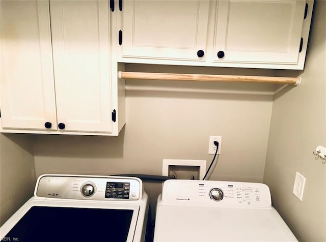 washroom featuring separate washer and dryer and cabinets