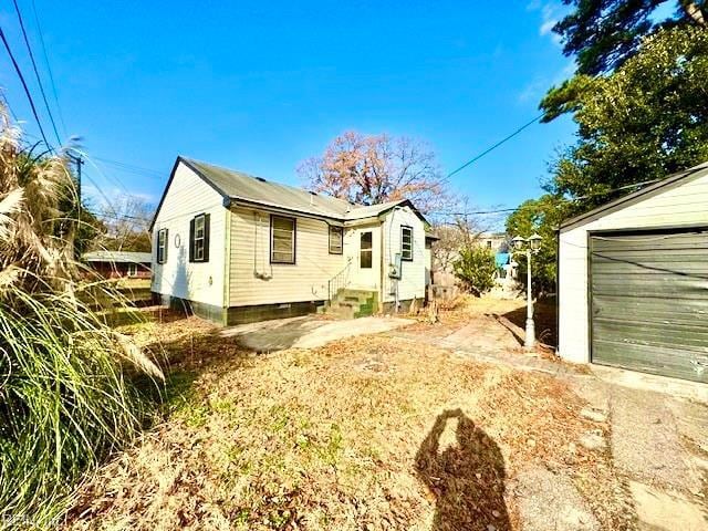 view of property exterior featuring a garage and an outbuilding