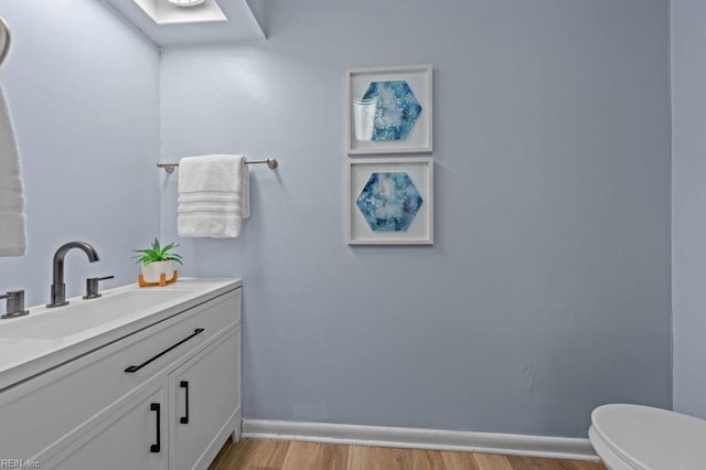 bathroom featuring vanity, toilet, and wood-type flooring