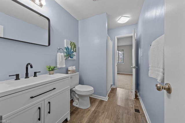 bathroom with vanity, hardwood / wood-style floors, and toilet