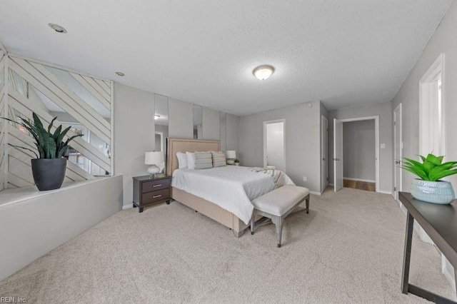 bedroom with light colored carpet and a textured ceiling