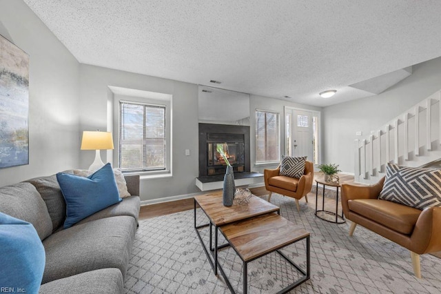 living room with a textured ceiling and light hardwood / wood-style flooring