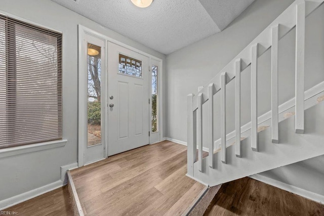 entrance foyer with a textured ceiling and light hardwood / wood-style floors