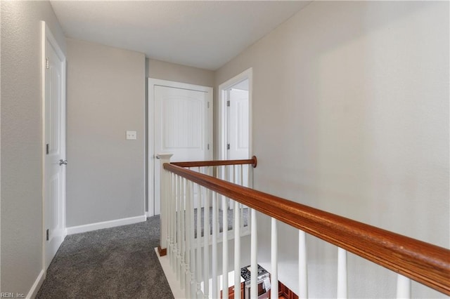 hallway featuring dark colored carpet