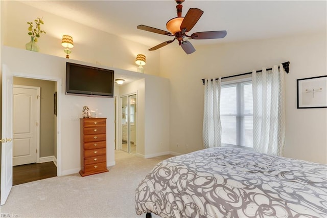 bedroom with ceiling fan, lofted ceiling, light colored carpet, and ensuite bath