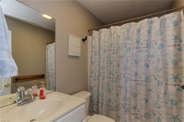 bathroom with a shower with curtain, vanity, toilet, and a textured ceiling