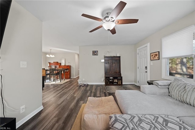 living room with dark wood-type flooring and ceiling fan with notable chandelier