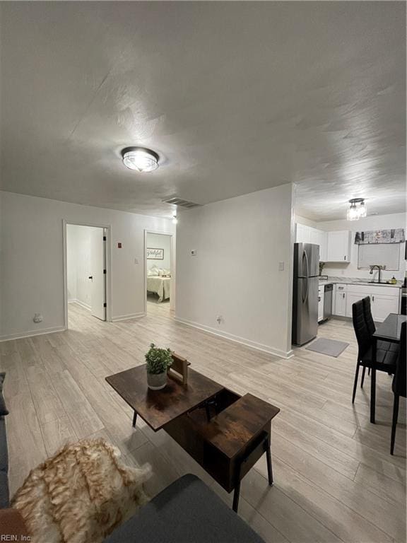 living room with sink and light hardwood / wood-style flooring