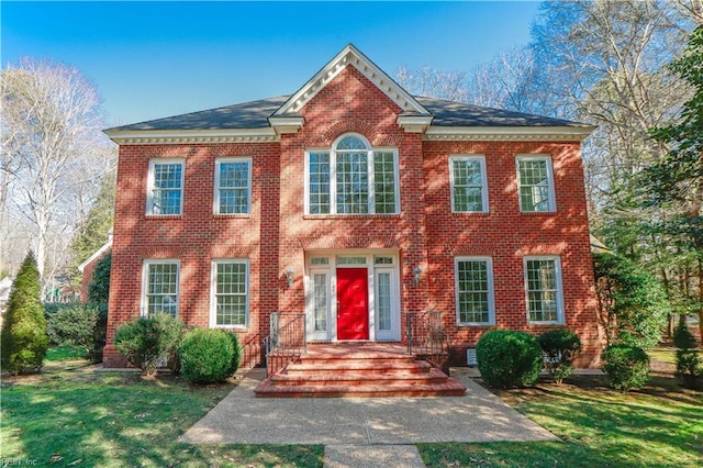 colonial inspired home featuring a front lawn