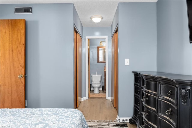 bedroom with hardwood / wood-style floors and a textured ceiling