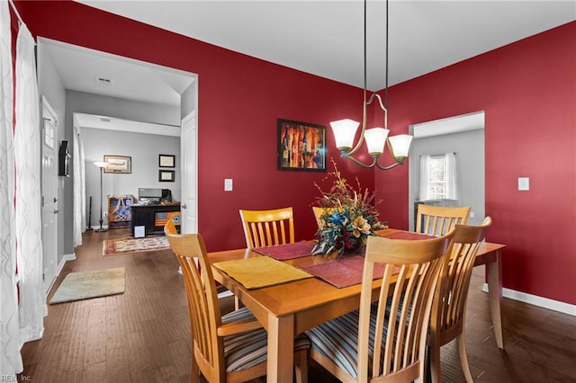 dining space featuring dark hardwood / wood-style floors and a notable chandelier