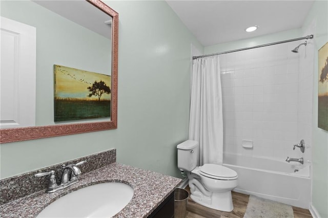 full bathroom with toilet, hardwood / wood-style floors, vanity, and shower / bath combo with shower curtain