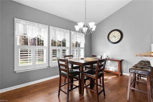 dining room featuring an inviting chandelier, lofted ceiling, and dark hardwood / wood-style flooring