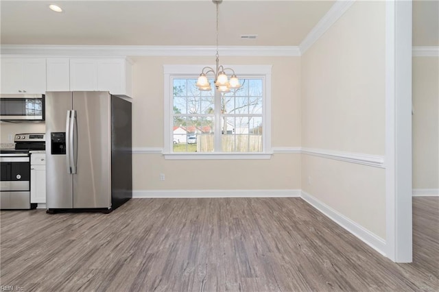 kitchen featuring white cabinetry, crown molding, hanging light fixtures, light wood-type flooring, and stainless steel appliances