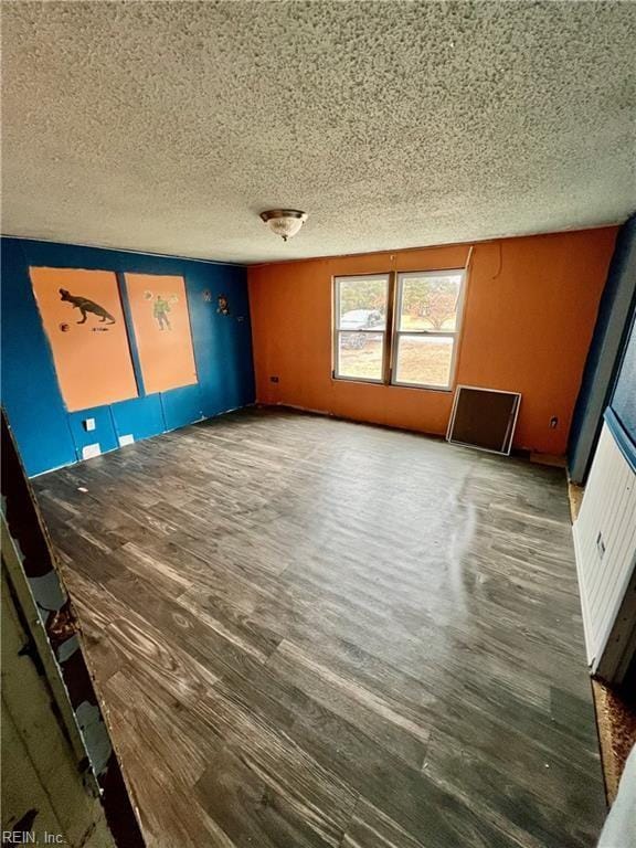 unfurnished room featuring hardwood / wood-style floors and a textured ceiling