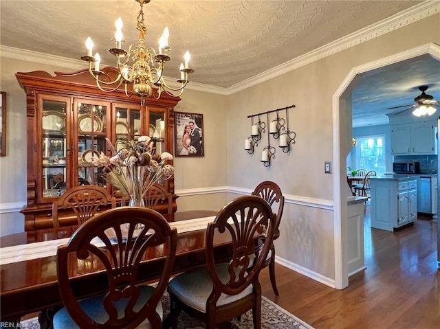 dining space with crown molding, dark wood-type flooring, and ceiling fan with notable chandelier