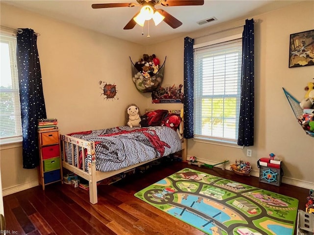 bedroom featuring multiple windows, ceiling fan, and dark hardwood / wood-style flooring