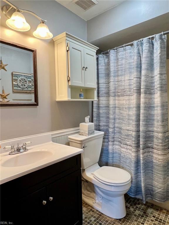 bathroom featuring vanity, toilet, curtained shower, and tile patterned flooring