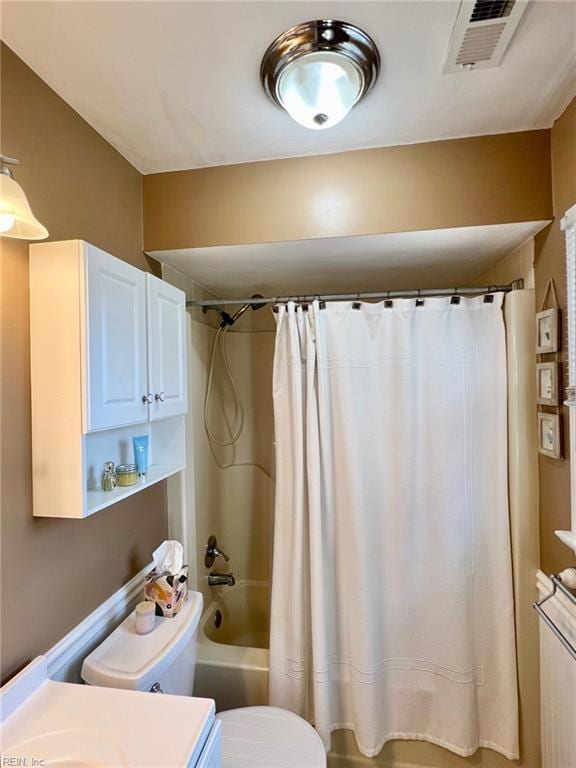 bathroom featuring shower / bathtub combination with curtain and toilet