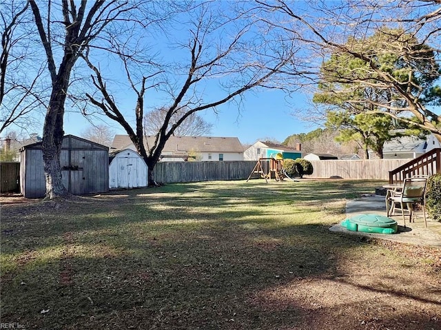 view of yard featuring a storage unit and a playground