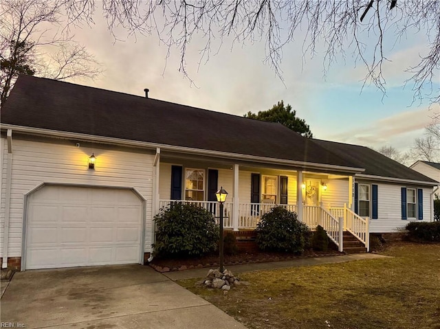 single story home featuring a garage, a porch, and a lawn