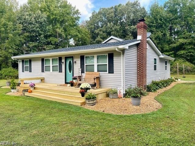 single story home featuring a wooden deck and a front yard