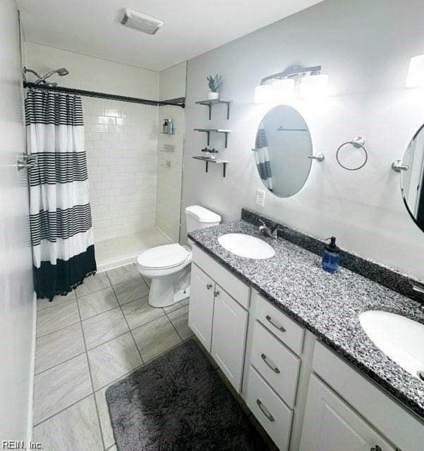 bathroom with vanity, curtained shower, and toilet