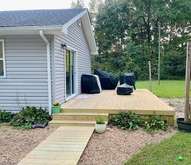 wooden terrace with a lawn