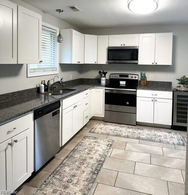 kitchen with white cabinetry, sink, wine cooler, and stainless steel appliances