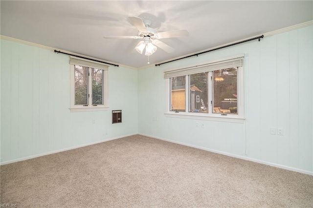 carpeted spare room featuring plenty of natural light, heating unit, and ceiling fan