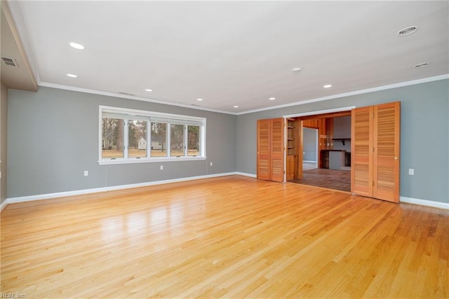 unfurnished living room with ornamental molding and light hardwood / wood-style floors