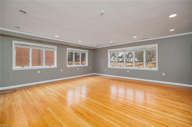 spare room featuring crown molding and light hardwood / wood-style floors