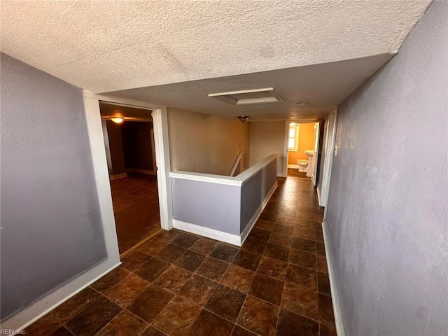 hall featuring a textured ceiling