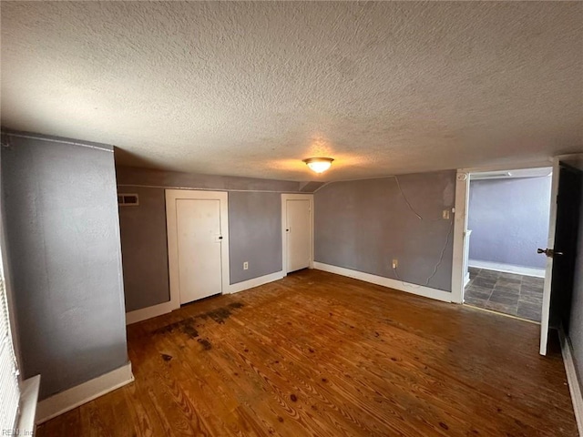 unfurnished bedroom featuring dark hardwood / wood-style floors and a textured ceiling