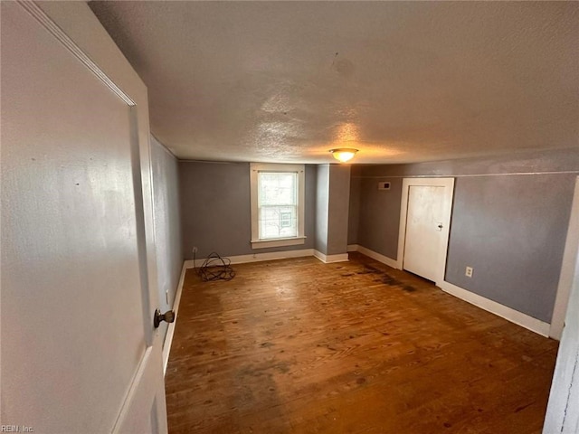 unfurnished room featuring wood-type flooring and a textured ceiling