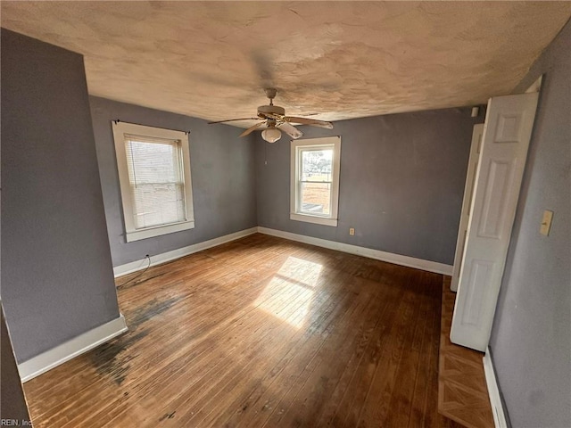 empty room with ceiling fan and wood-type flooring