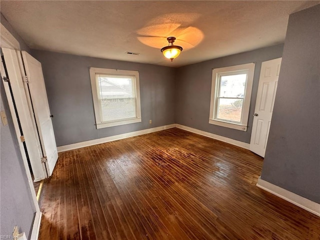 unfurnished bedroom featuring dark hardwood / wood-style flooring