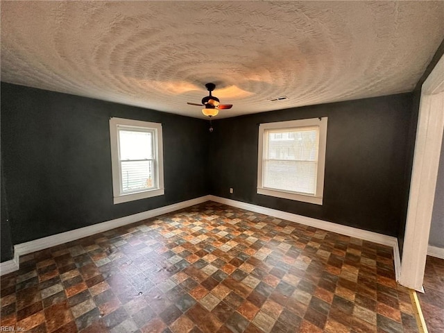 spare room featuring a textured ceiling and ceiling fan