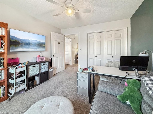 carpeted office space with ceiling fan and a textured ceiling