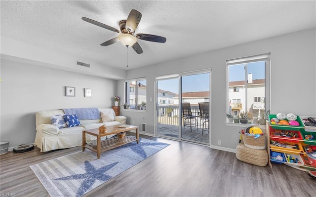 living room featuring hardwood / wood-style floors, a textured ceiling, and ceiling fan