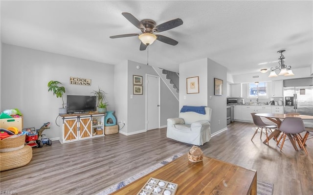 living room with ceiling fan, wood-type flooring, and sink