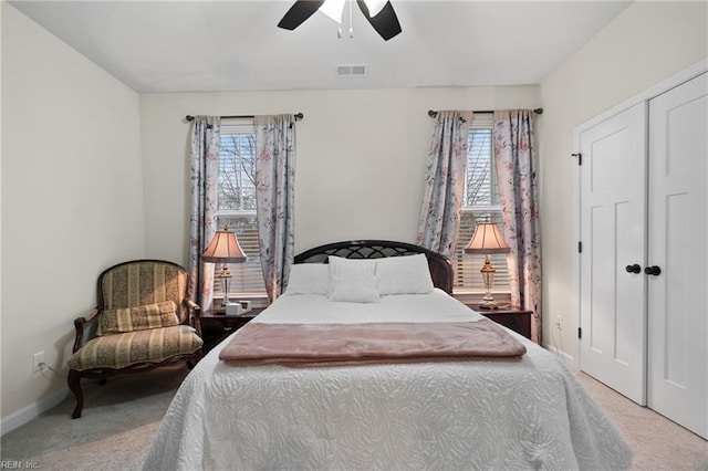 carpeted bedroom with multiple windows, ceiling fan, and a closet