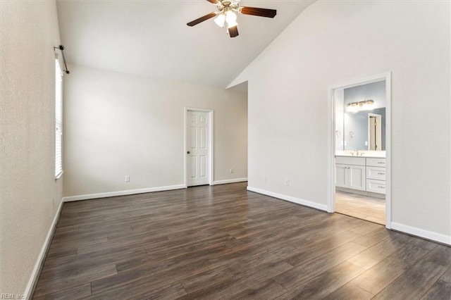 spare room with high vaulted ceiling, dark wood-type flooring, and ceiling fan